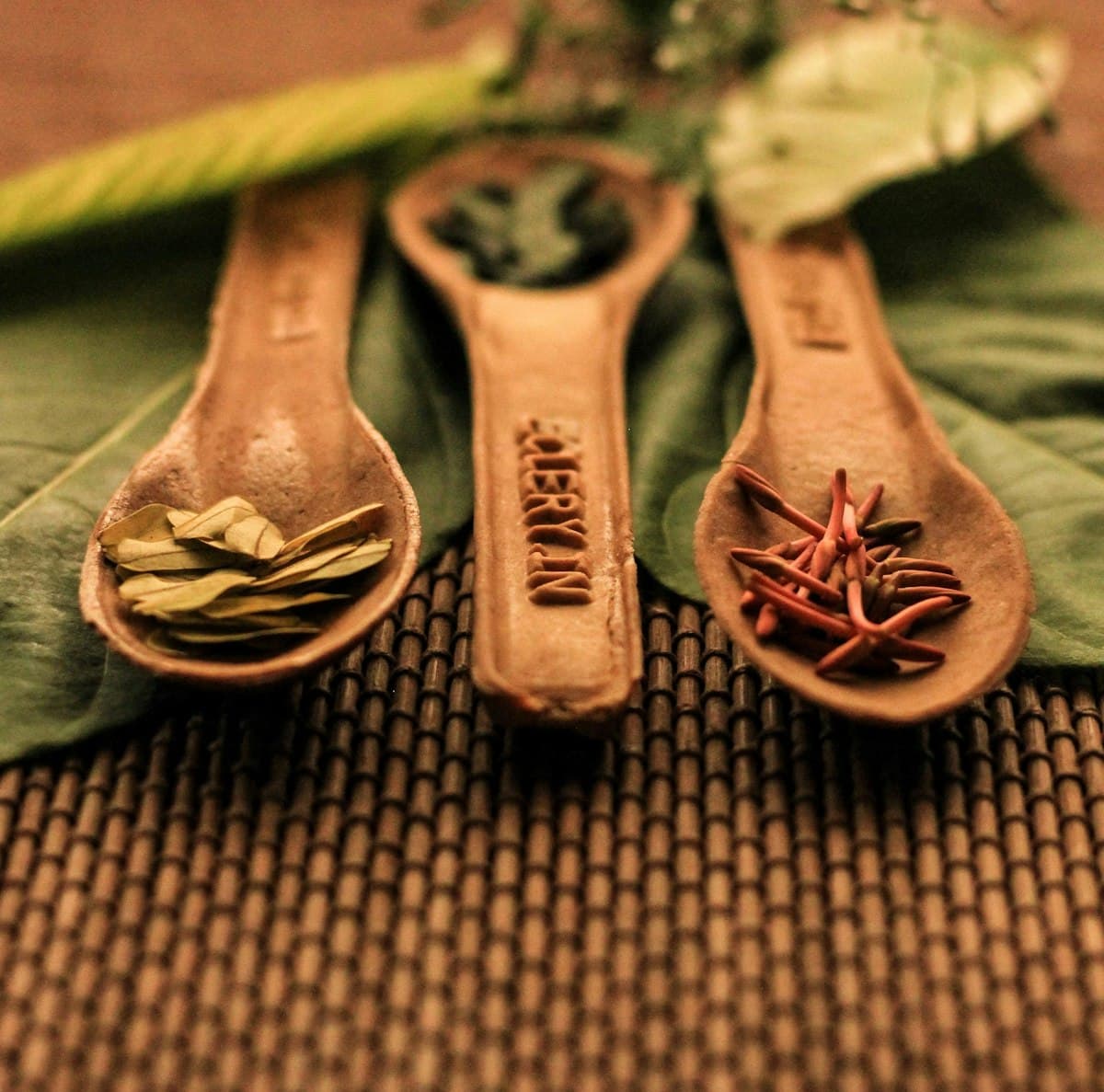 Traditional Ayurvedic herbs and spoons on a leaf